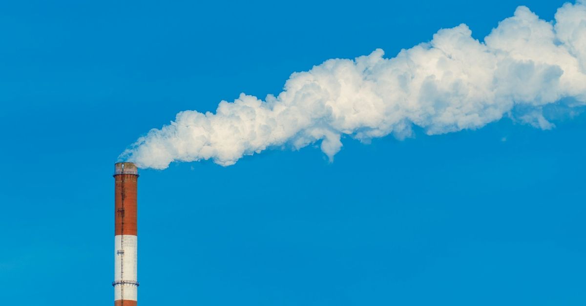 a-smokestack-with-a-cloud-of-smoke-in-the-sky